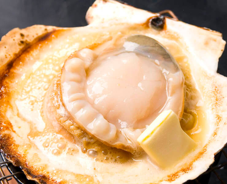 活ホタテのバター焼き 【道産】764円（税込）<br>活ホタテならではのプリプリの食感！<br>丸ごと楽しめる貝殻付です。